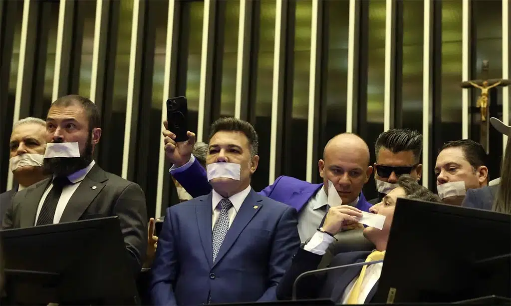 Câmara dos Deputados – Parlamentares da oposição tapam a boca em protesto no plenário. (Foto: Reprodução)